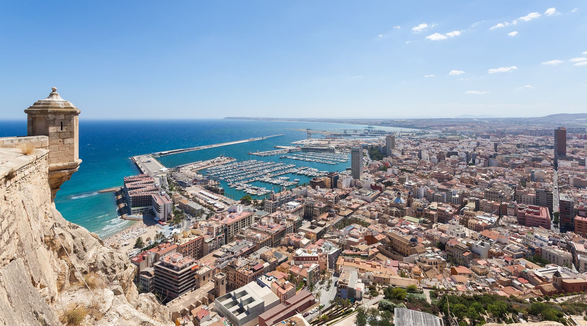 Uitzicht vanaf het Castillo de Santa Bárbara over de daken van Alicante, de jachthaven en de blauwe Middellandse Zee