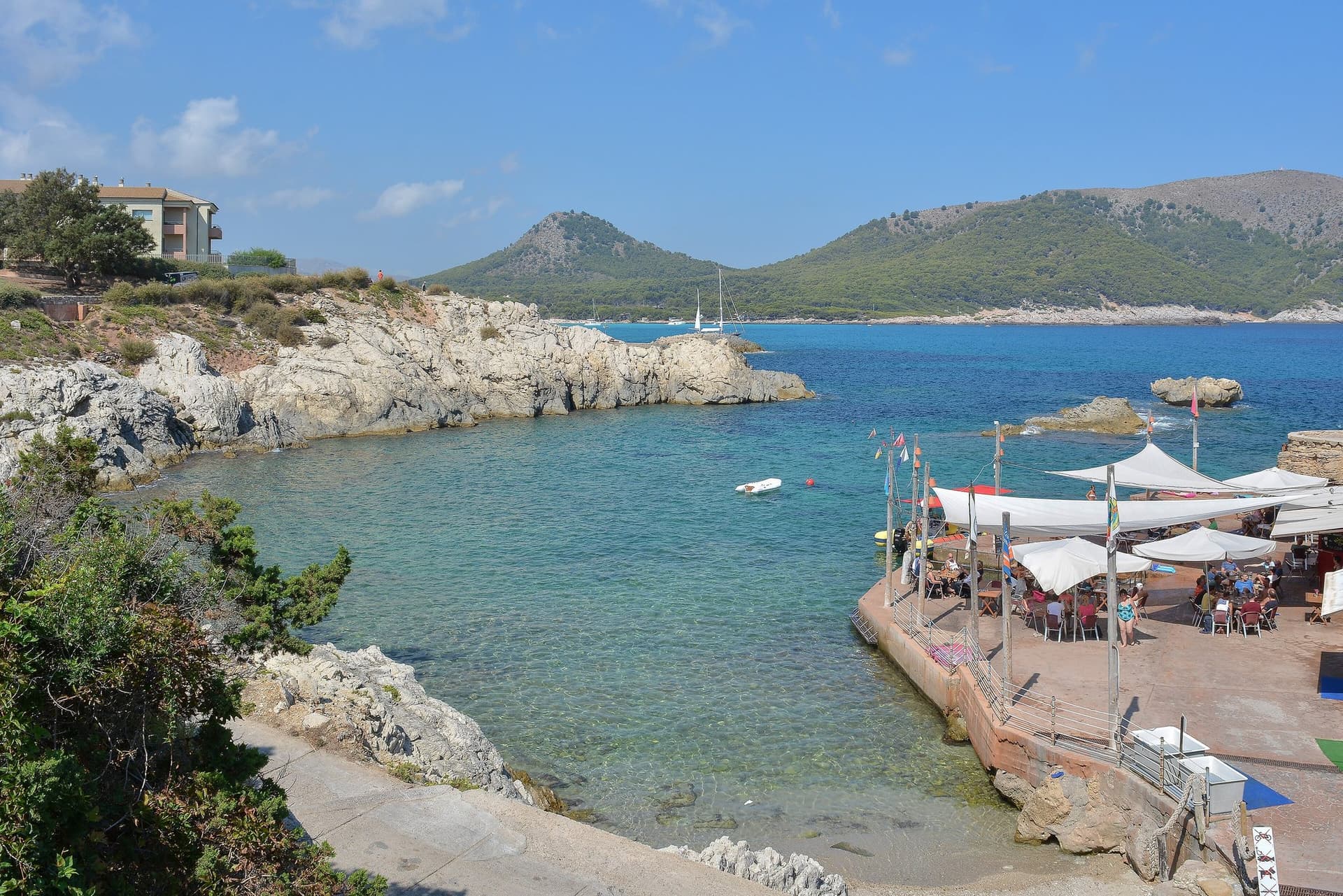Een kleine baai met helder water bij Cala Ratjada in het noordoosten van Mallorca, met een terras aan het water