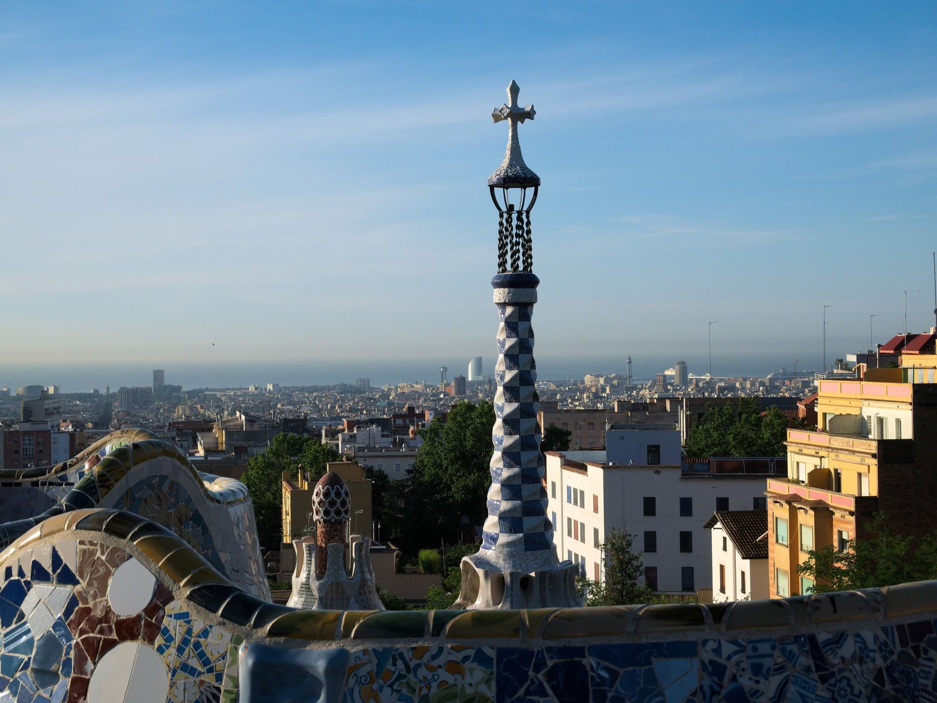 Mozaïektoren en golvende bank van Park Güell met uitzicht over Barcelona en de zee