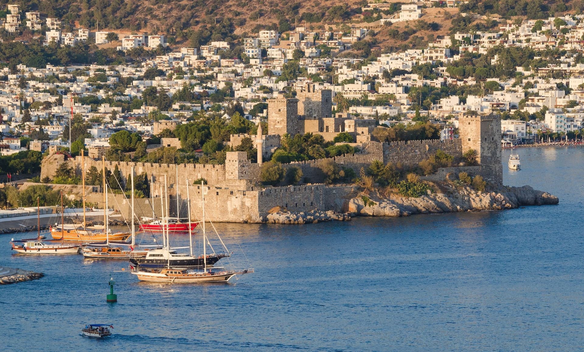 Kasteel van Sint-Petrus in Bodrum met zeilboten in de baai en witte huizen op de heuvel
