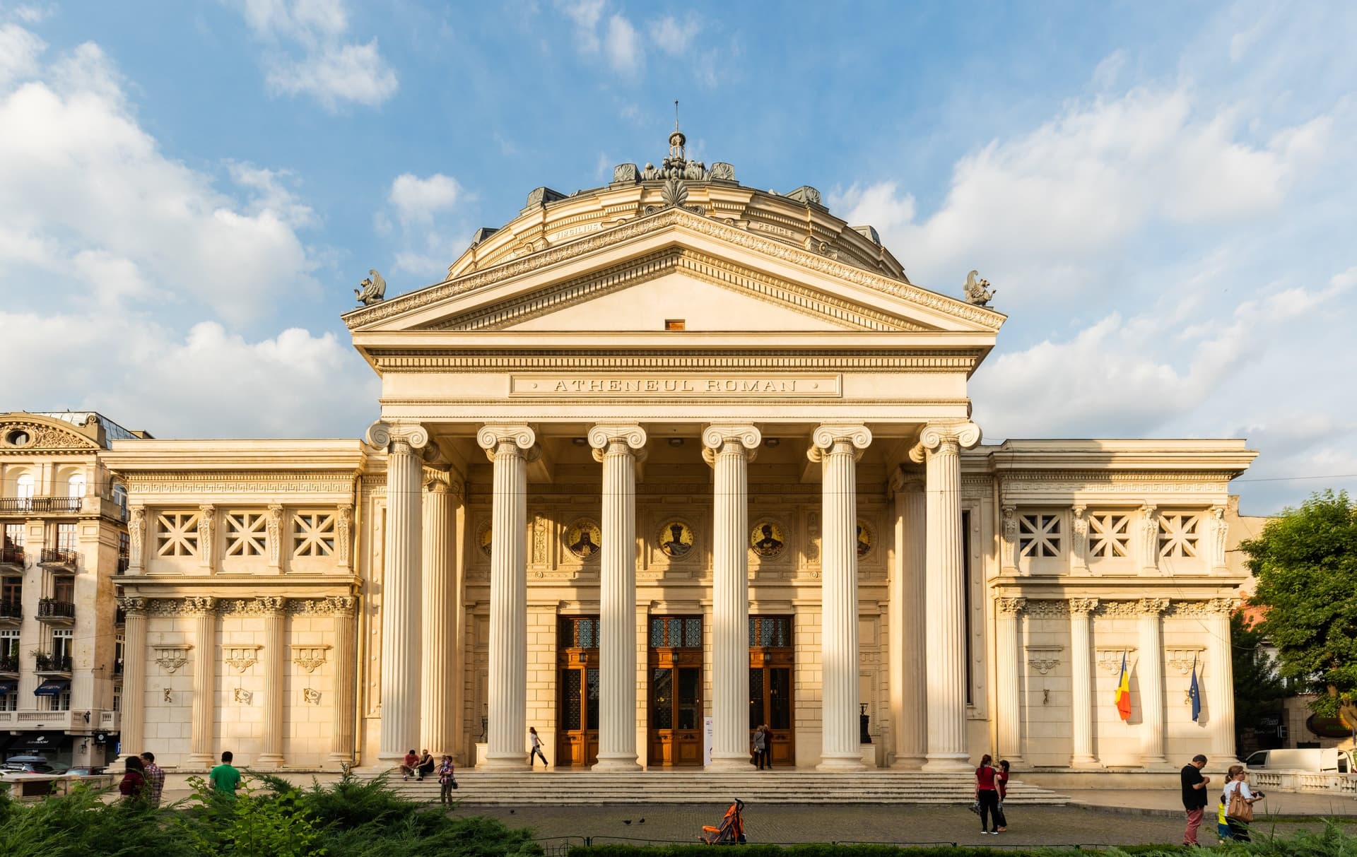 Het Roemeens Atheneum in Boekarest met zijn zuilenportiek en koepel onder een zonnige lucht met wolken