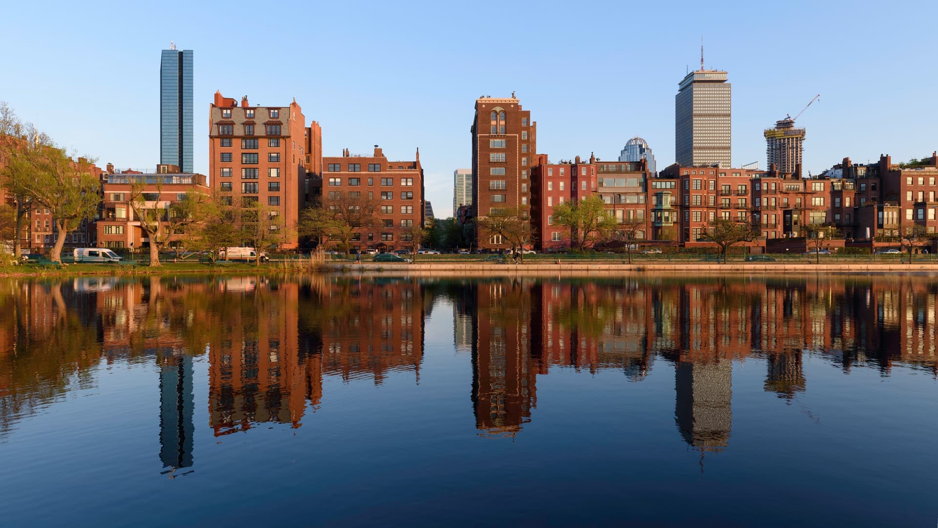 Bakstenen huizen van Back Bay en de torens van het Prudential Center en 200 Clarendon weerspiegeld in de Storrow Lagoon aan de Charles River Esplanade in Boston