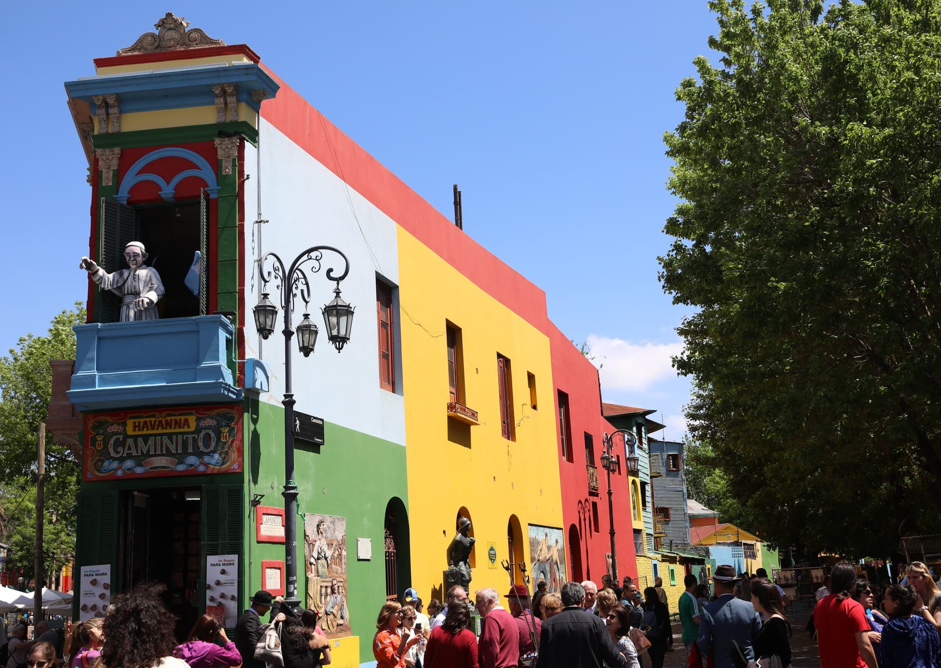 Felgekleurde gevels in blauw, groen, geel en rood aan de Caminito in La Boca, Buenos Aires, onder een strakblauwe lucht
