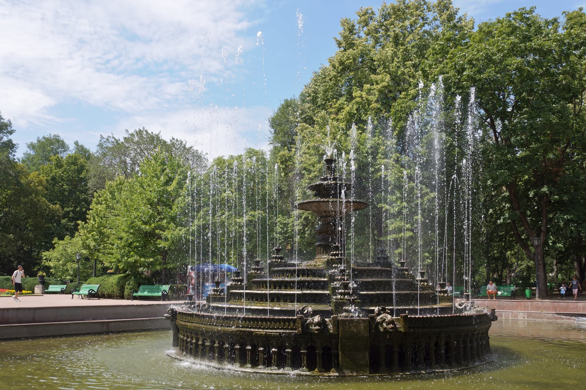 Spuitende fontein tussen hoge bomen in het Stefan cel Mare-park in het centrum van Chisinau op een zonnige dag