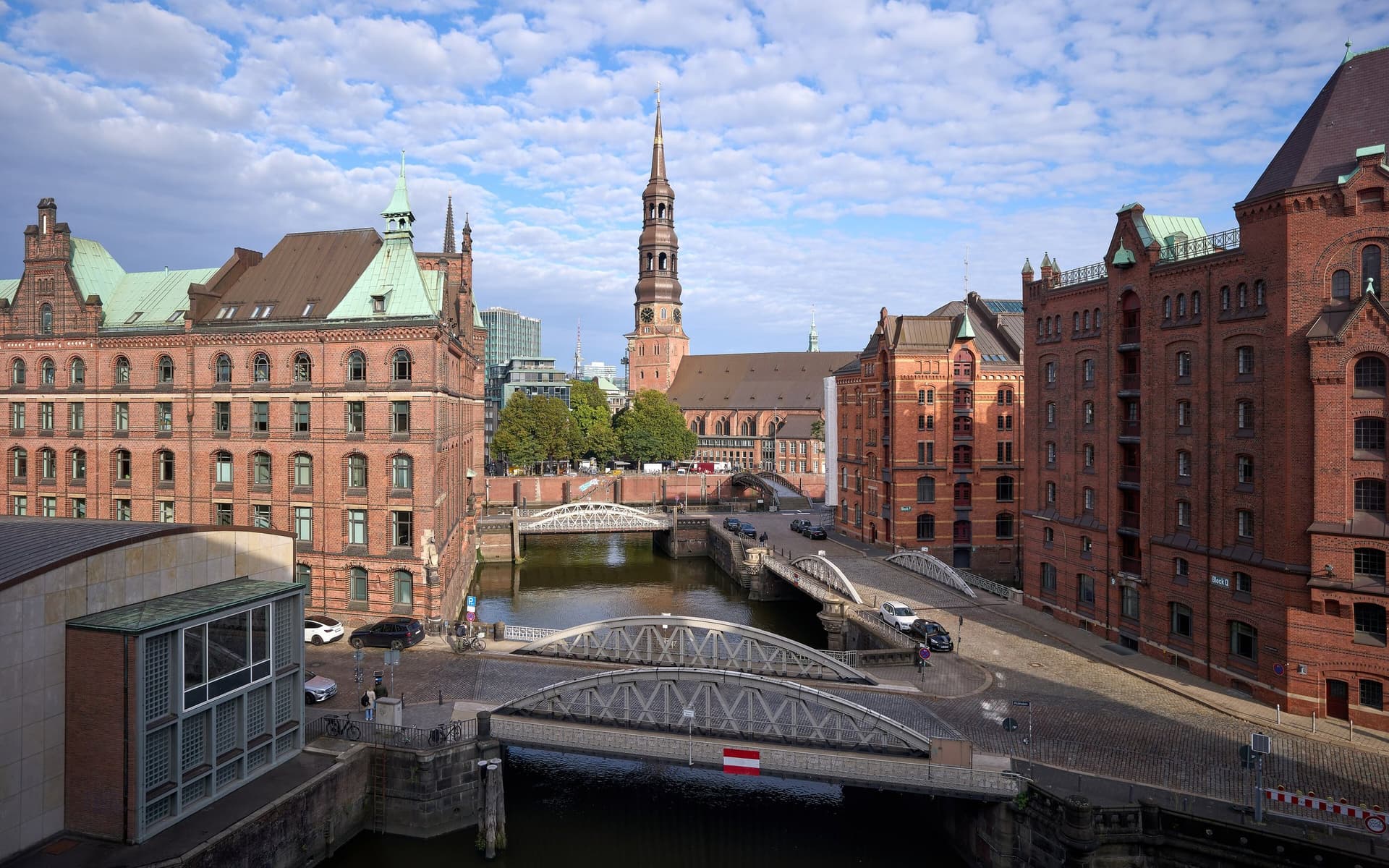 De Speicherstadt in Hamburg met rode bakstenen pakhuizen, bruggetjes over het Fleet en de toren van de St. Katharinenkirche