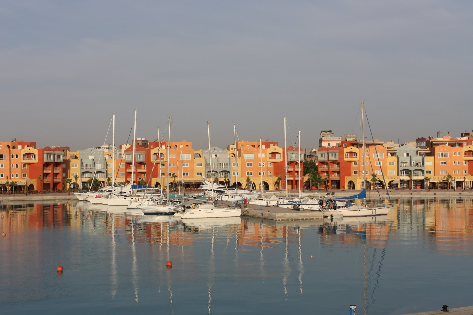 Zeiljachten in de marina van Hurghada voor kleurrijke gebouwen in het ochtendlicht