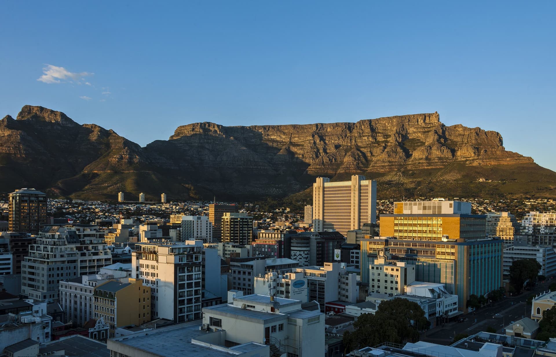 Het centrum van Kaapstad met kantoortorens in de City Bowl, daarachter de platte Tafelberg onder een blauwe lucht