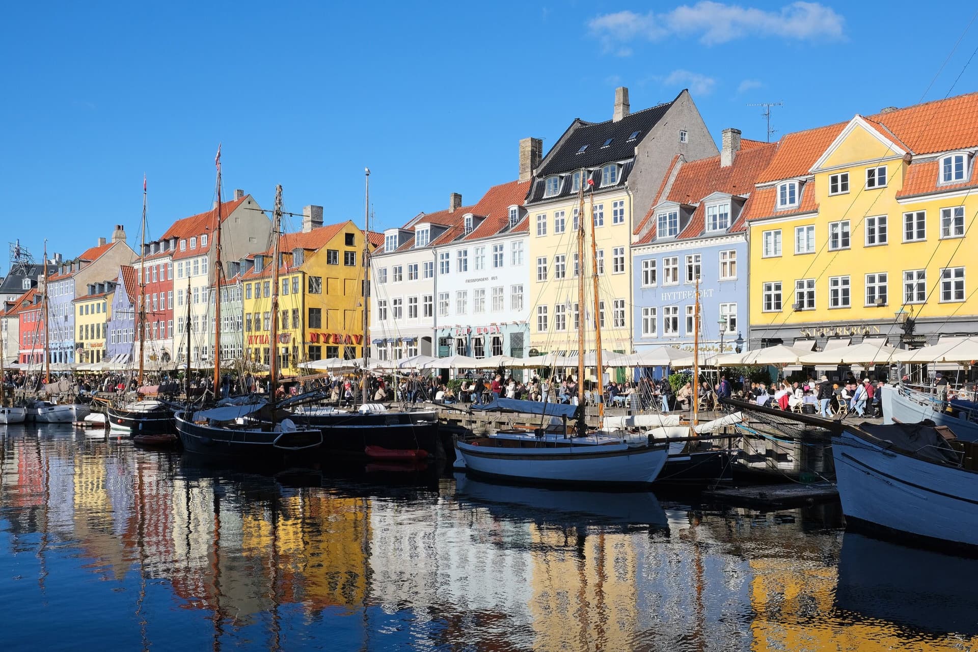 Kleurrijke grachtenpanden en houten zeilboten aan de Nyhavn in Kopenhagen
