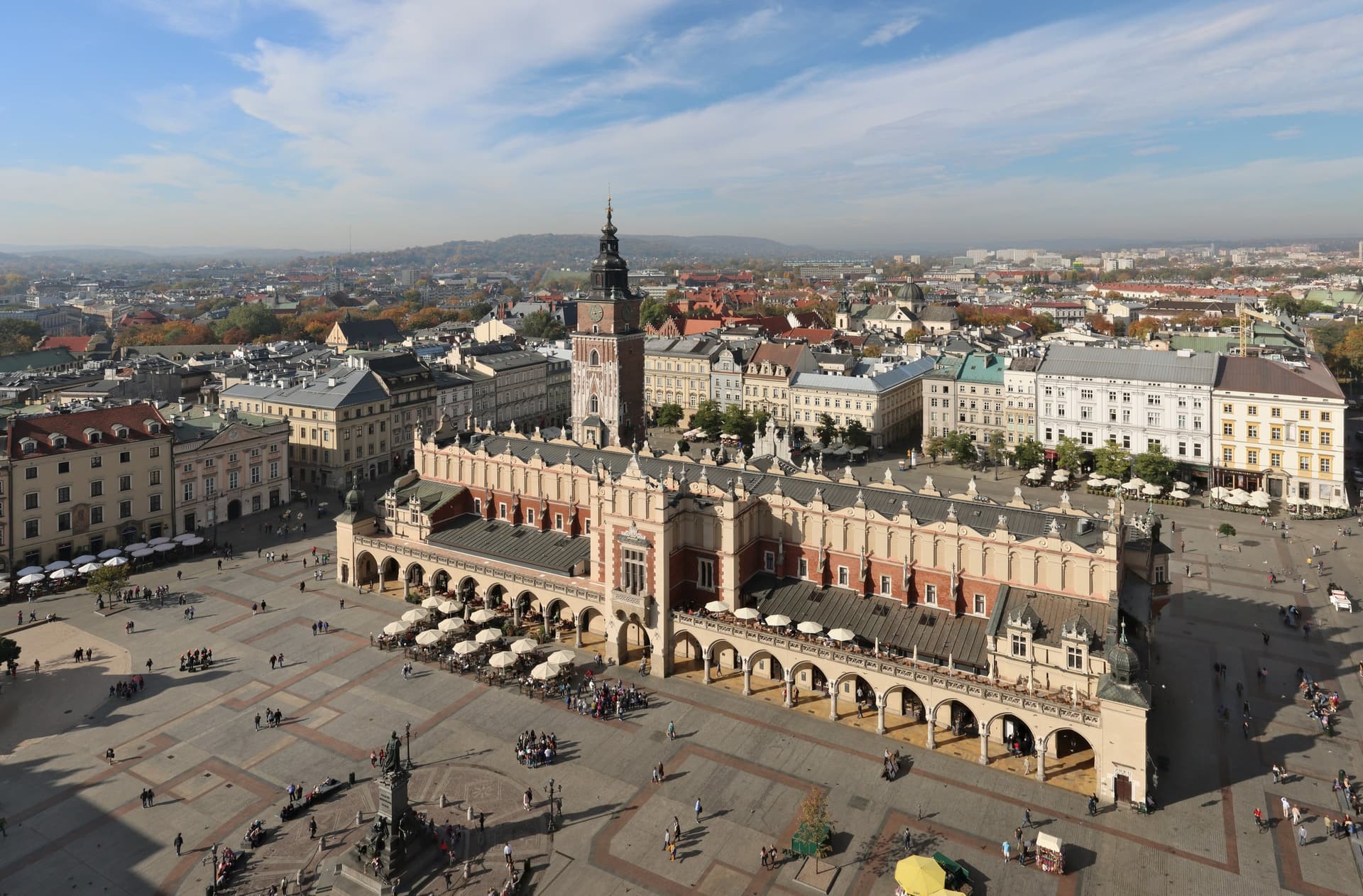 De Lakenhal midden op het zonnige Rynek Główny in Krakau, van bovenaf gezien met terrassen en daken tot aan de horizon