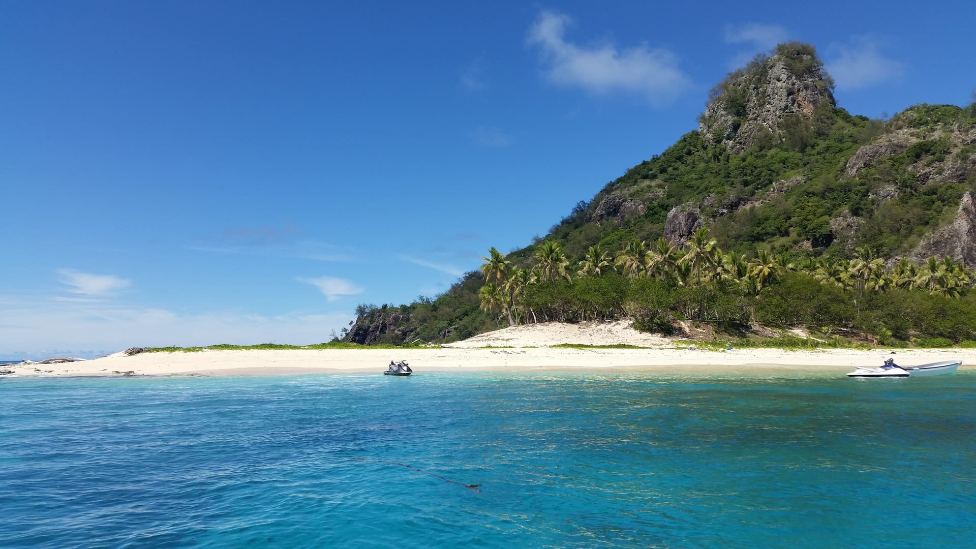 Het eiland Monuriki in de Mamanuca-groep voor de kust bij Nadi, met een wit strand, palmen en een rotsige top boven turquoise water
