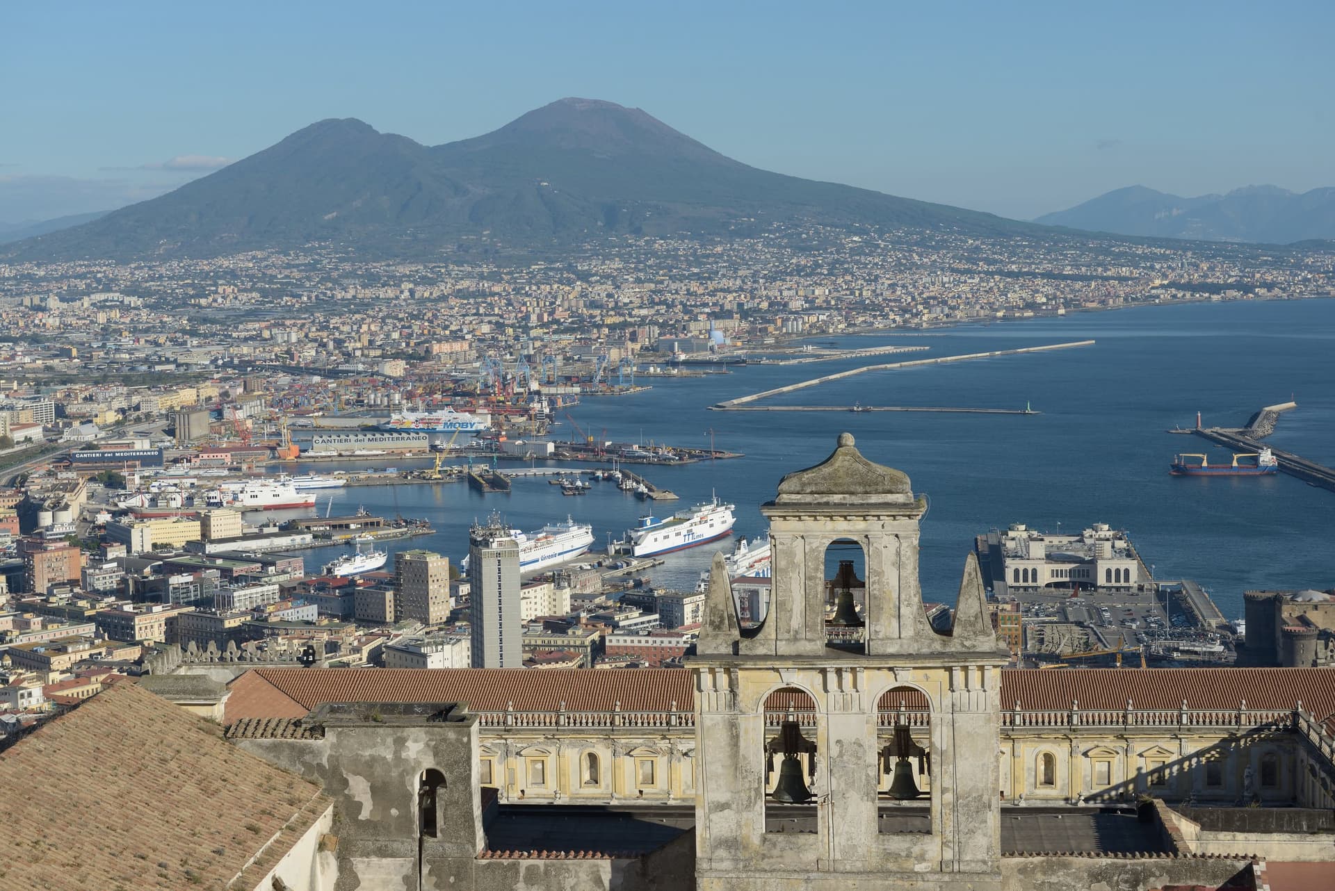 Uitzicht vanaf Castel Sant'Elmo over Napels, de haven en de Vesuvius, met de klokkentoren van de Certosa di San Martino op de voorgrond