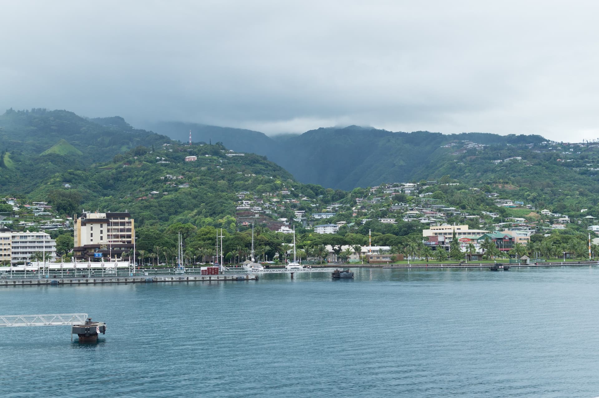 De haven van Papeete op Tahiti gezien vanaf de veerboot naar Moorea, met de stad aan het water en groene bergen erachter