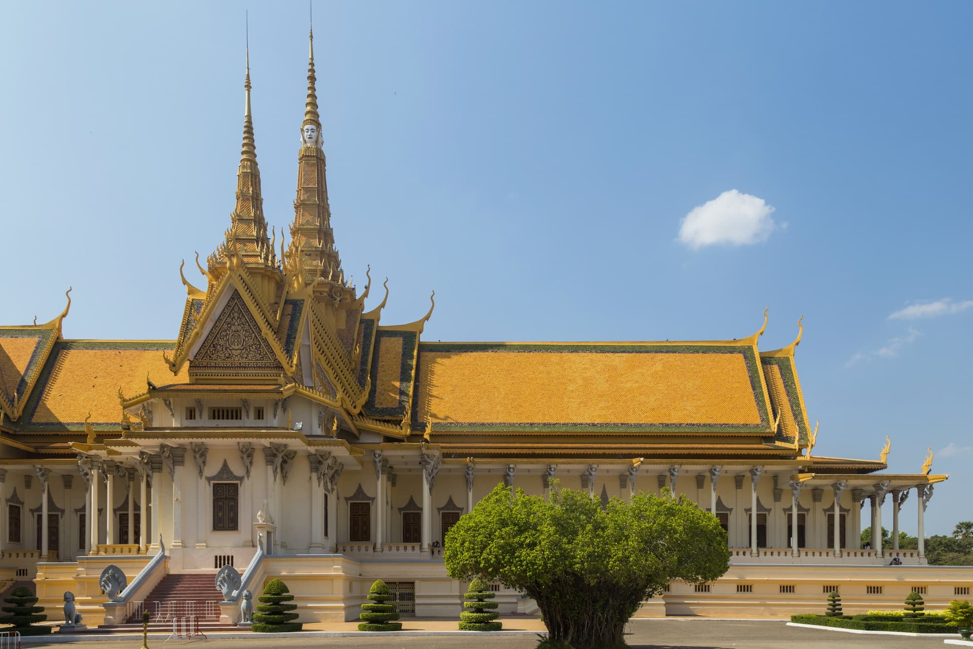 De Troonzaal van het Koninklijk Paleis in Phnom Penh met goudgele daken en hoge spitsen onder een blauwe lucht