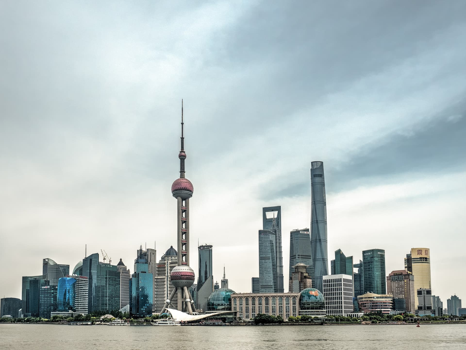 De skyline van Lujiazui in Shanghai gezien vanaf de Bund, met de Oriental Pearl Tower en de Shanghai Tower aan de overkant van de Huangpu-rivier