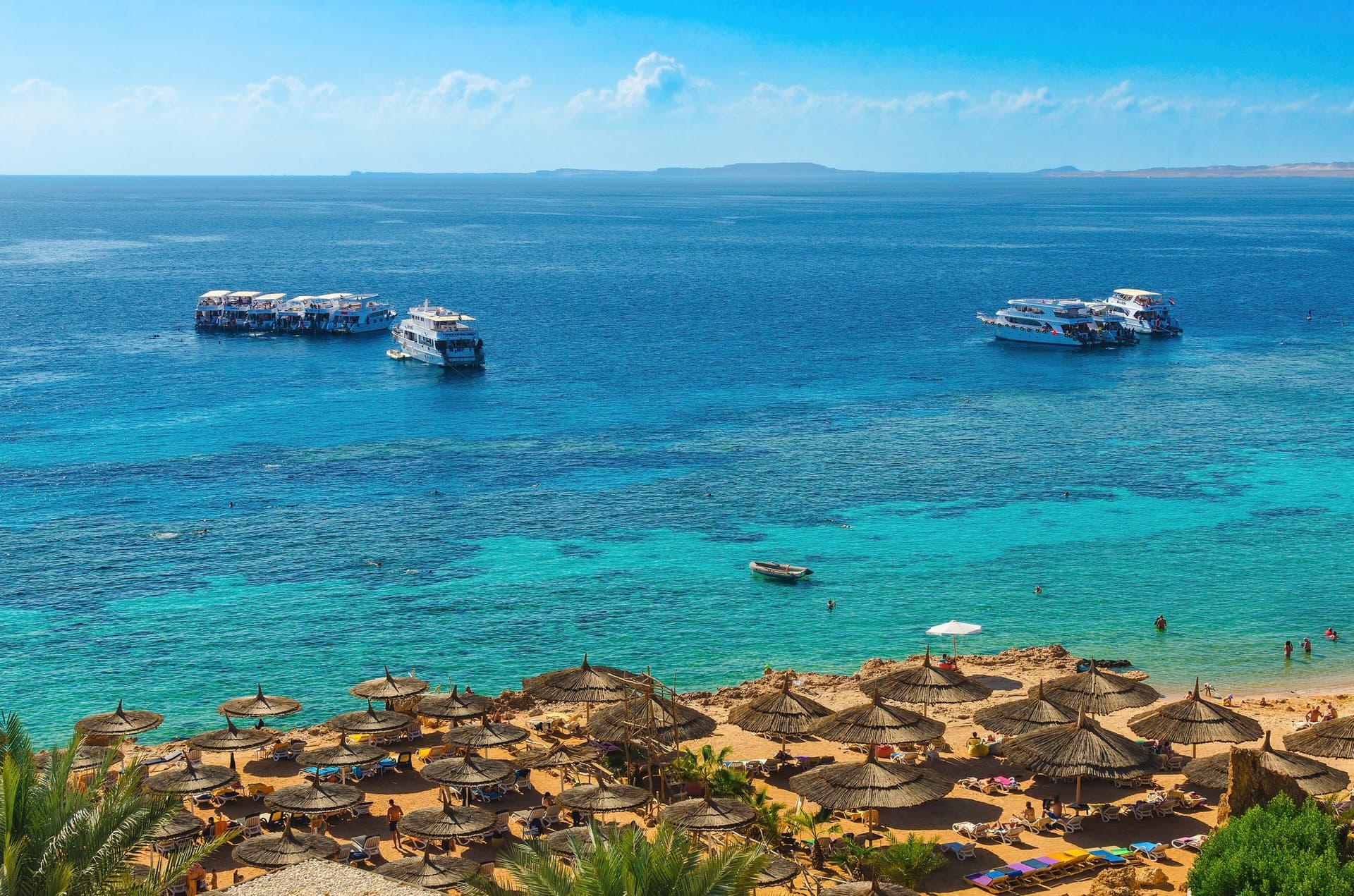Turquoise Rode Zee en strand met parasols bij Ras Um Sid in Sharm el-Sheikh