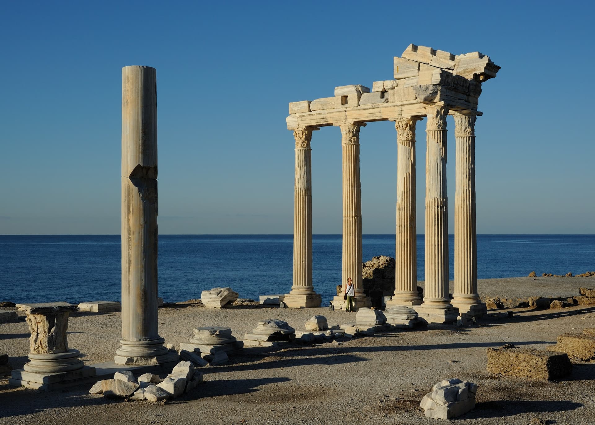 De zuilen van de Romeinse Apollotempel op het schiereiland van Side, met de blauwe Middellandse Zee en een strakblauwe lucht erachter