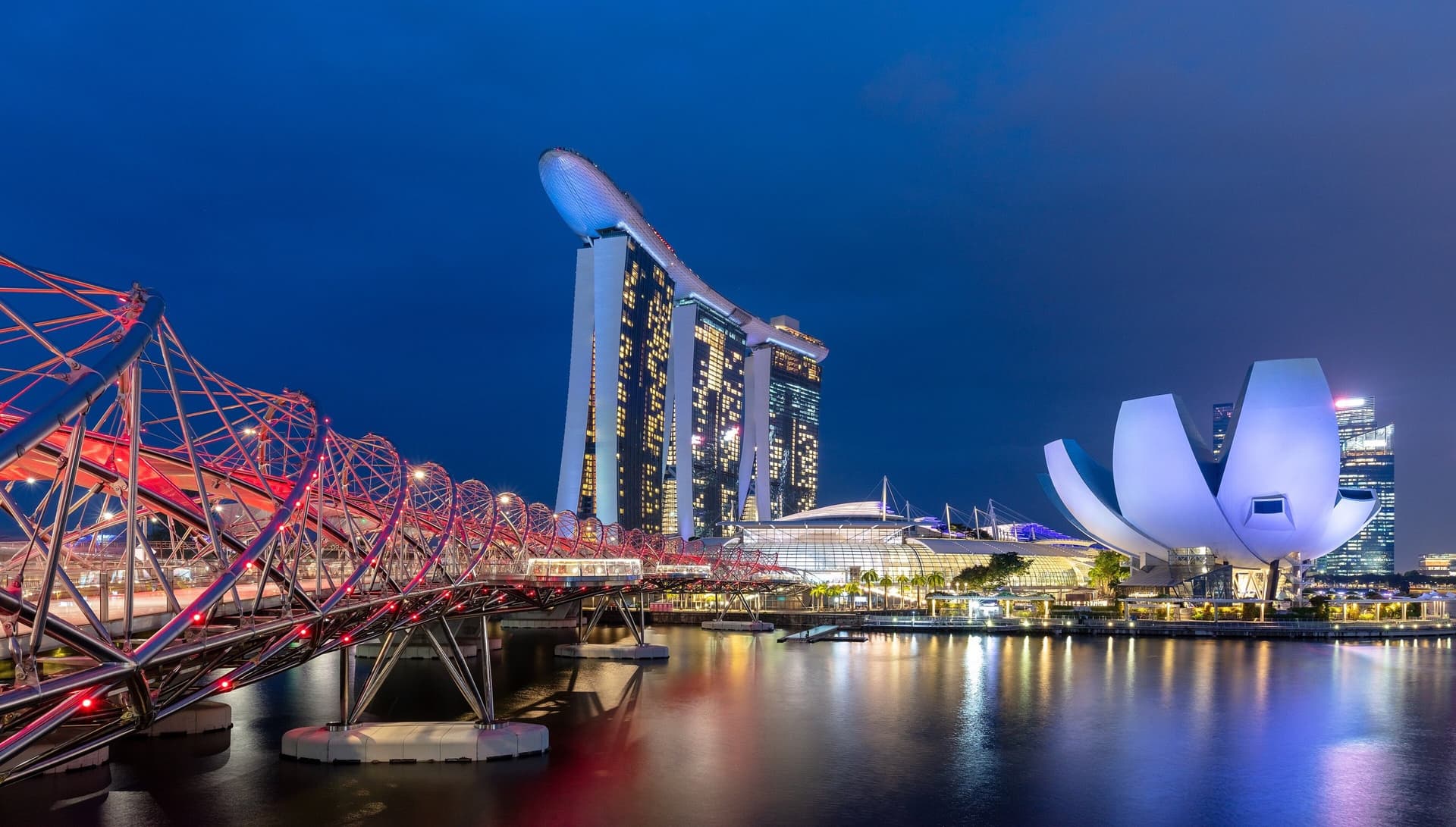 Marina Bay Sands, het ArtScience Museum en de verlichte Helix Bridge aan de Marina Bay in Singapore tijdens het blauwe uur