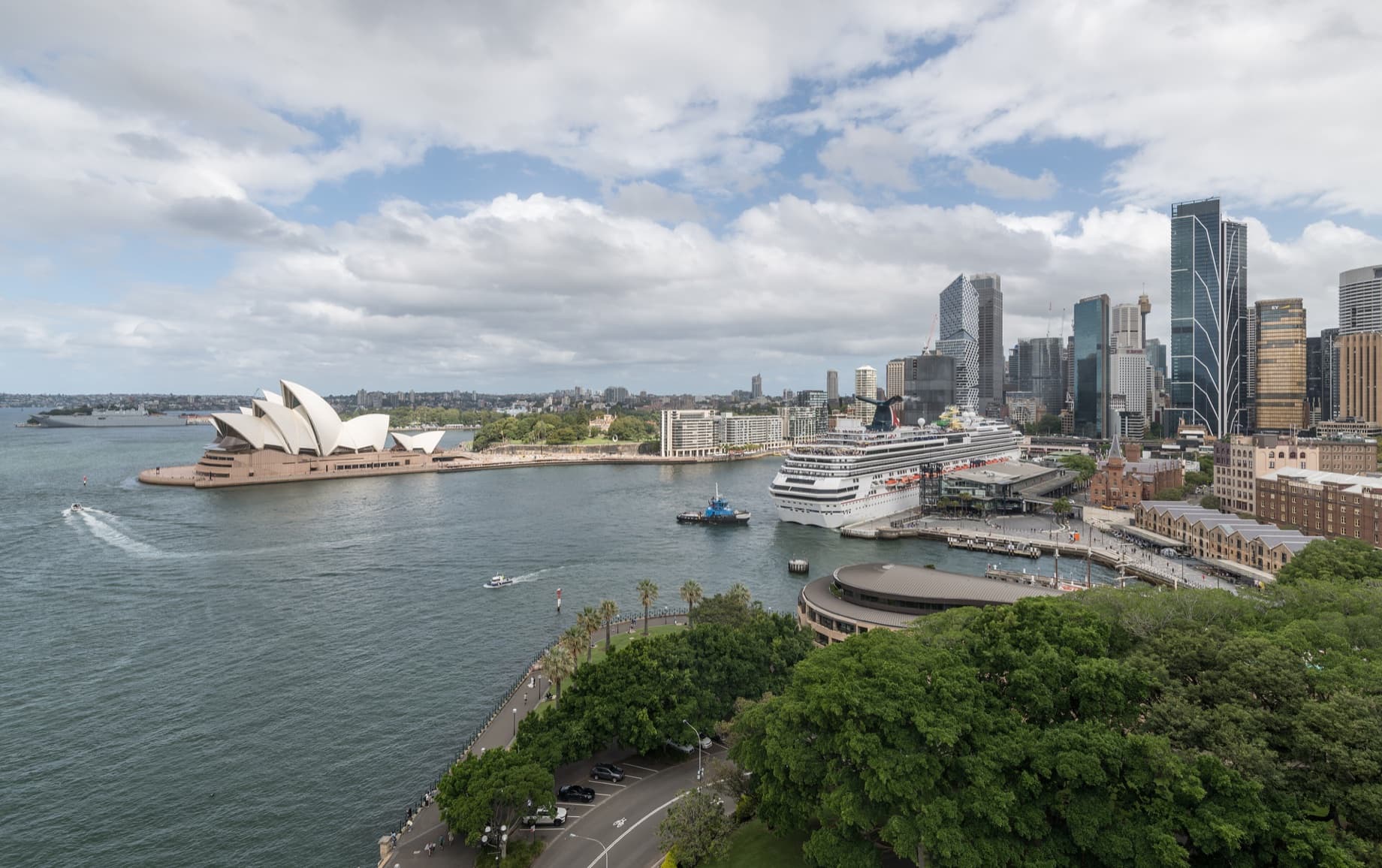 Uitzicht over Circular Quay in Sydney met links het Sydney Opera House, een cruiseschip aan de kade en rechts de torens van het CBD