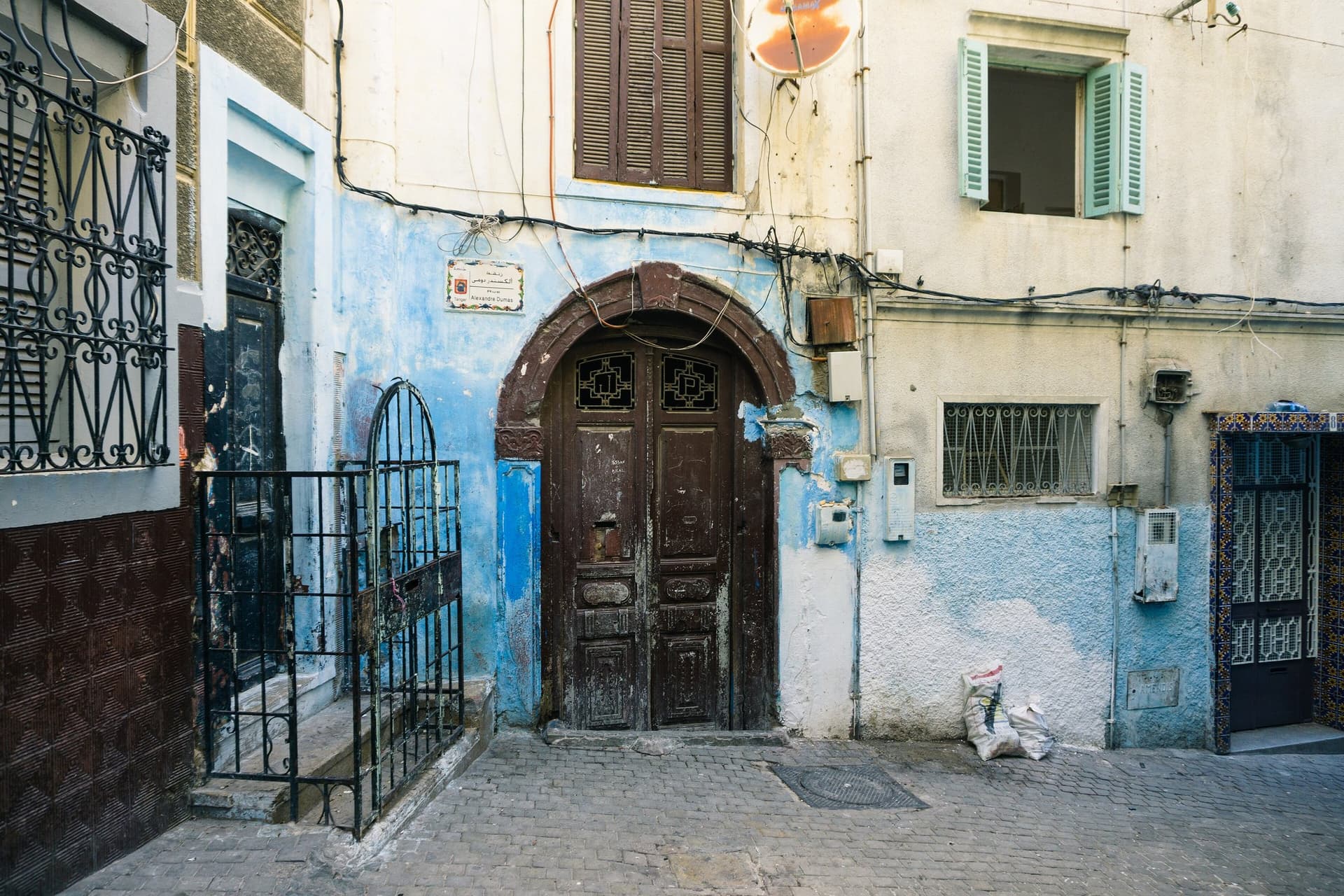 Blauwwit geschilderde gevels en een houten deur in de medina van Tanger