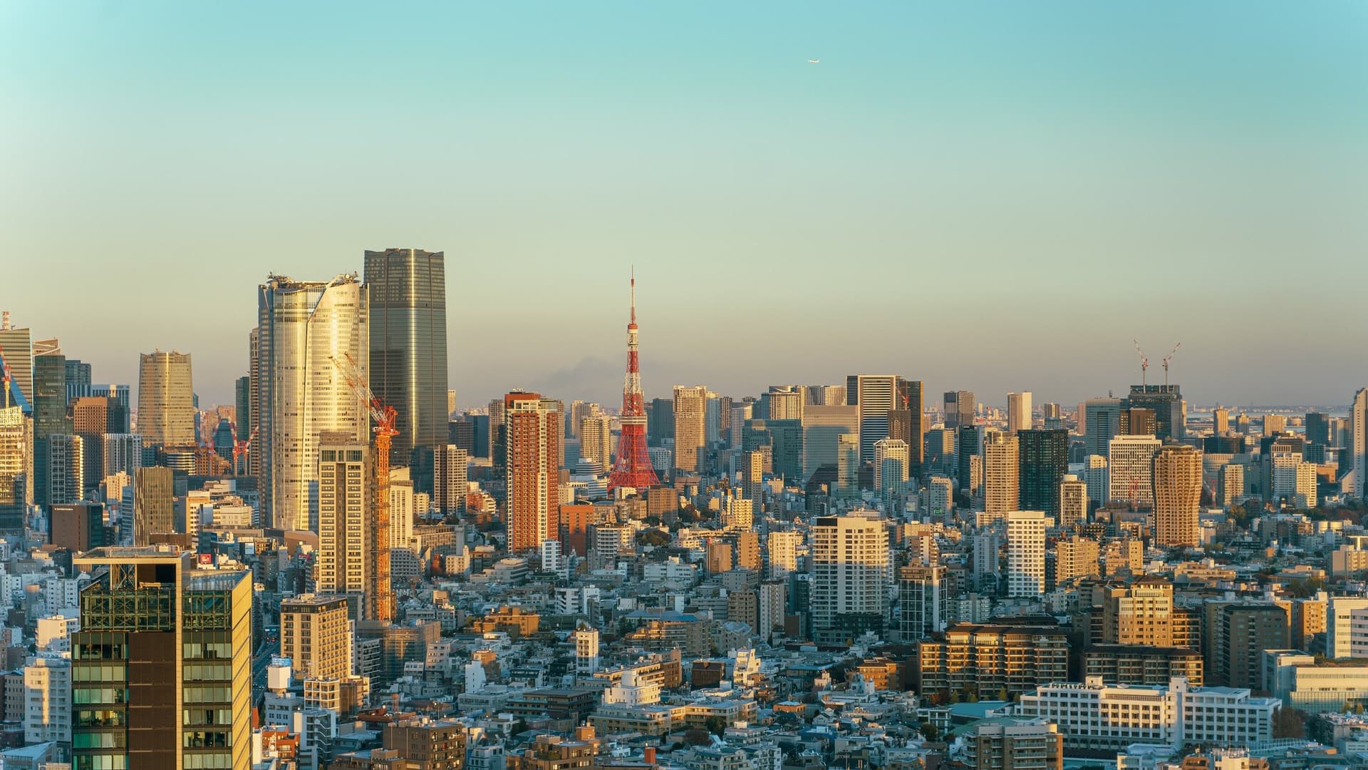 De skyline van Minato in Tokio met de rood-witte Tokyo Tower in het gouden avondlicht