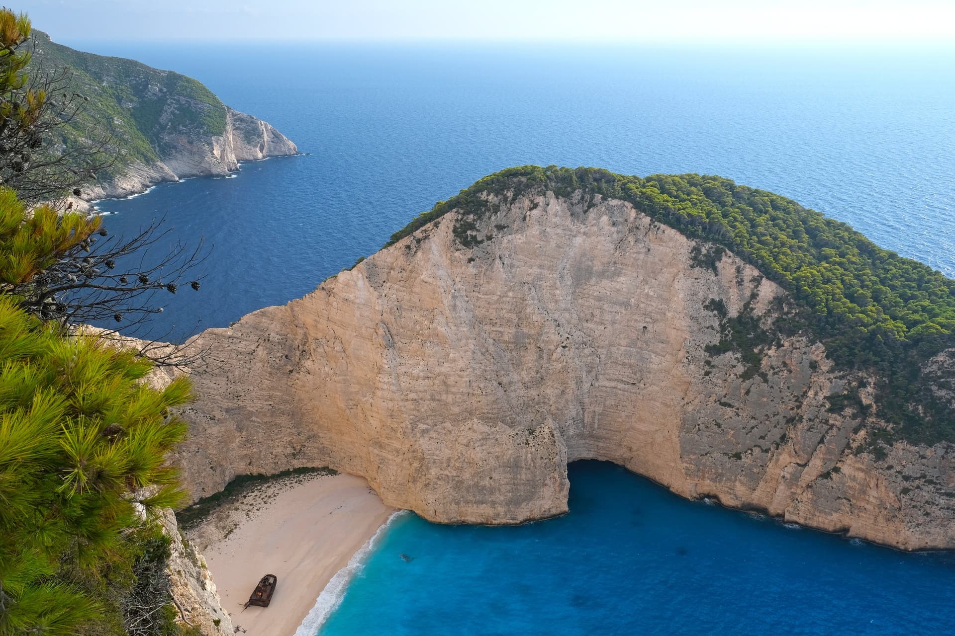 De baai van Navagio op Zakynthos van bovenaf gezien, met het scheepswrak op het witte strand tussen steile kalkrotsen en turquoise water