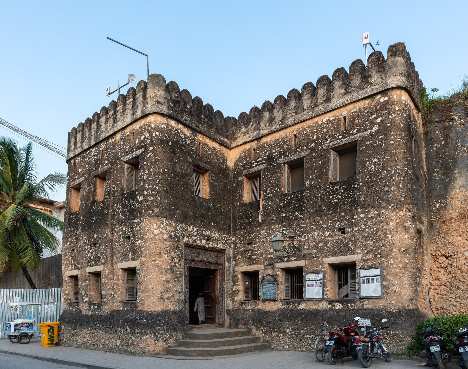Het koraalstenen Old Fort (Ngome Kongwe) met kantelen in Stone Town, Zanzibar, onder een strakblauwe lucht